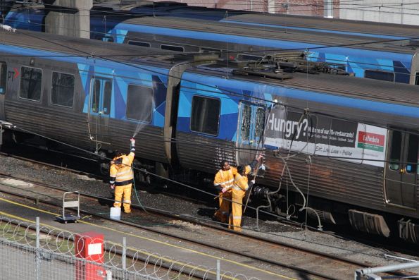 Washing down a Comeng train by hand at Melbourne Yard