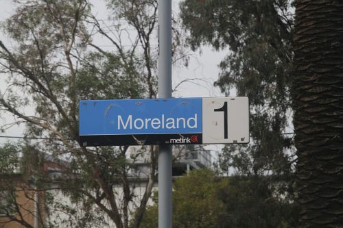 Metlink station sign expose beneath the PTV coverplate at Moreland station